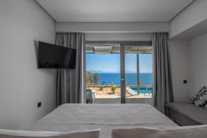 a bedroom with a bed and a view of the ocean at Adrina Grand Hotel in Panormos Skopelos