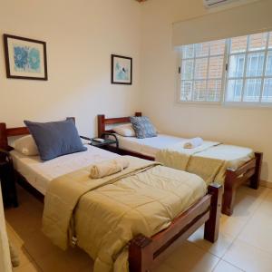 ein Zimmer mit zwei Betten und einem Fenster in der Unterkunft G2 Casa en Villa Ángela 2 dormitorios con Garage Independiente in Villa Ángela