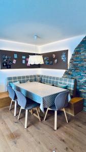 ein Esszimmer mit einem Tisch und zwei blauen Stühlen in der Unterkunft Casa Terza - CharmingStay in Flumserberg