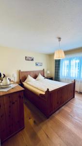 ein Schlafzimmer mit einem großen Holzbett und einem Tisch in der Unterkunft Casa Terza - CharmingStay in Flumserberg