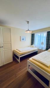 ein Hotelzimmer mit 2 Betten und einem Fenster in der Unterkunft Casa Terza - CharmingStay in Flumserberg