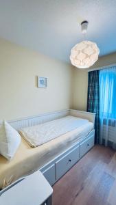 Bett in einem Zimmer mit Fenster und Licht in der Unterkunft Casa Terza - CharmingStay in Flumserberg