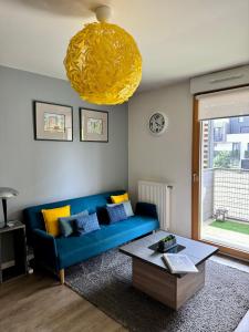 a living room with a blue couch and a table at Studio 2 adultes 2 enfants parcs Disneyland Paris in Montévrain