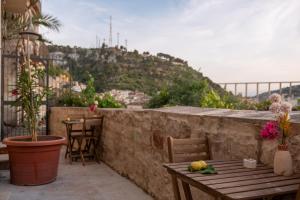 a patio with a table and chairs and a mountain at Villa Gelsomino in Modica
