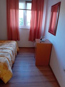 um quarto com uma cama, uma cómoda e uma janela em Tina em Pula