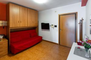 sala de estar con sofá rojo y TV en appartamento a 50 mt dal mare, en Porto SantʼElpidio