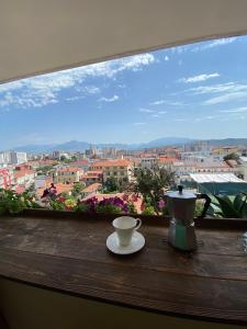 une fenêtre avec une tasse et une théière sur une table dans l'établissement Stay the Night Shkodra Apartment City Centre, à Shkodër
