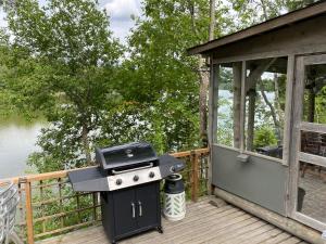 a grill on a deck next to a house at Rantamökki Cottage Vihti near Nuuksio in Huhmari
