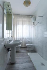 Baño blanco con lavabo y aseo en appartamento a 50 mt dal mare, en Porto SantʼElpidio