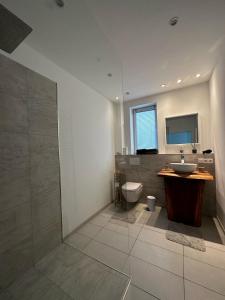 a bathroom with a sink and a toilet at Paradies in den Bergen nahe Garmisch Partenkirchen in Eschenlohe