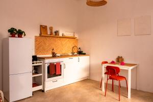 a small kitchen with a white refrigerator and a table at Villa Gelsomino in Modica