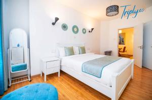 une chambre blanche avec un grand lit et un miroir dans l'établissement Soho B21, à Nairobi