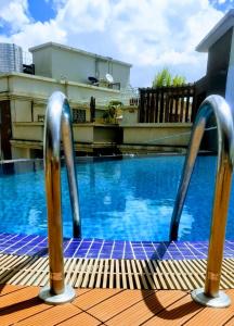 une piscine avec deux poignées en métal devant elle dans l'établissement Soho B21, à Nairobi