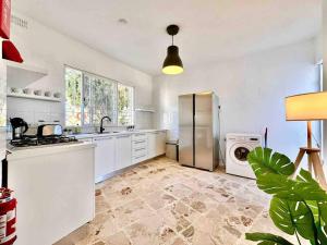 a kitchen with a refrigerator and a washing machine at Poolside Paradise Sea View Villa in Is-Swieqi