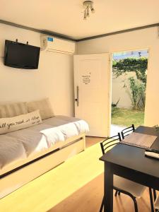 een kamer met een bed, een tafel en een televisie bij "Casa Amalia Apartamentos" Plaza Italia y Av Arístides a 50mts, lugar con jardín in Mendoza