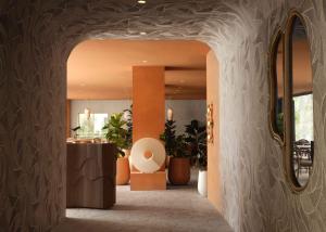 a hallway with an archway in a building with plants at Sandbourne Santa Monica, Autograph Collection in Los Angeles