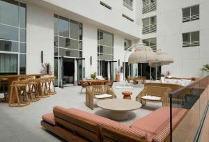 a lobby of a building with chairs and tables at Sandbourne Santa Monica, Autograph Collection in Los Angeles
