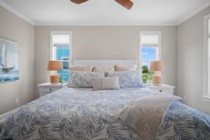 a bedroom with a large bed with two windows at Lowcountry State of Mind luxury beach getaway located on Harbor Island, South Carolina in St. Helena Island