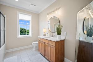 a bathroom with a sink and a toilet and mirrors at Lowcountry State of Mind luxury beach getaway located on Harbor Island, South Carolina in St. Helena Island +41 photos