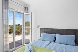 a bedroom with a bed and a balcony at Villa Sunny Olive in Peroj +52 photos