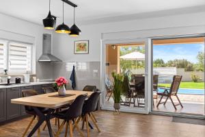 a kitchen and dining room with a table and chairs at Villa Sunny Olive in Peroj