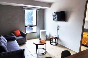 a living room with a couch and a tv at Hermoso departamento cerca del Auditorio Telmex in Guadalajara