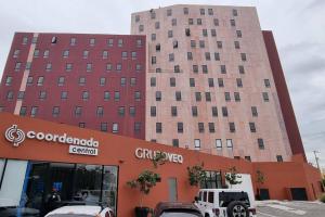 a large building with cars parked in front of it at Hermoso departamento cerca del Auditorio Telmex in Guadalajara