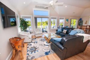 ein Wohnzimmer mit Sofa und Tisch in der Unterkunft Soundside, Hot Tub, Community Pool, Sound Views, VOH1248, Sunset Cottage in Corolla