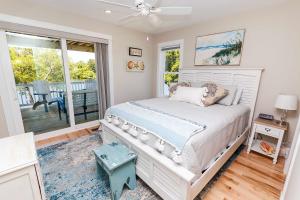 ein Schlafzimmer mit einem Bett und einem Balkon in der Unterkunft Soundside, Hot Tub, Community Pool, Sound Views, VOH1248, Sunset Cottage in Corolla