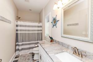 ein Badezimmer mit Waschbecken und Spiegel in der Unterkunft Soundside, Hot Tub, Community Pool, Sound Views, VOH1248, Sunset Cottage in Corolla + 55 Fotos