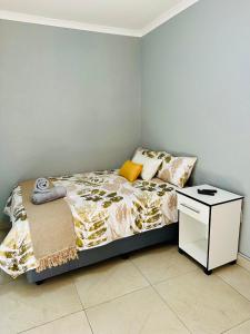 a bedroom with a bed and a night stand at Maekano guesthouse in Kwamhlanga