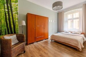 sypialnia z łóżkiem, szafką i krzesłem w obiekcie Apartament ROZETA centrum 6os w mieście Legnica