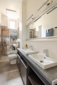 łazienka z 2 umywalkami, toaletą i lustrem w obiekcie Apartament ROZETA centrum 6os w mieście Legnica