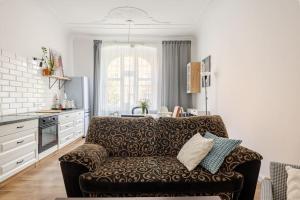 a living room with a couch and a kitchen at Apartament ROZETA centrum 6os in Legnica