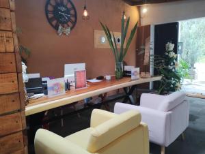 an office with a desk and two chairs and a clock at Encino House Hotel & Glamping Valle de Bravo in Valle de Bravo