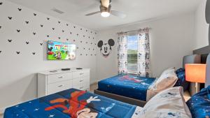 ein Schlafzimmer mit zwei Betten und einem Schreibtisch in der Unterkunft Stunning Townhouses 5 Minutes away Disney! in Kissimmee