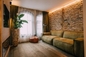 a living room with a couch and a brick wall at TheBridge29 boutique apartment in Breda
