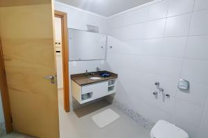 Baño blanco con lavabo y aseo en Saint Sebastian ap103-stúdio PNE, en Jaraguá do Sul