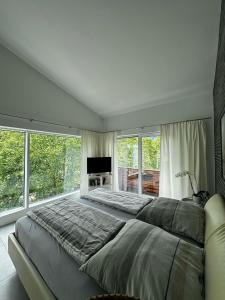 a large bedroom with a large bed and windows at Paradies in den Bergen nahe Garmisch Partenkirchen in Eschenlohe