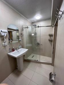 a bathroom with a glass shower and a sink at Hotel Legende in Samarkand