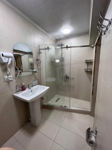 a bathroom with a glass shower and a sink at Hotel Legende in Samarkand +37 photos