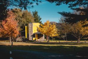 a building in the middle of a park with trees at La Candelaria Casas de campo in Tandil