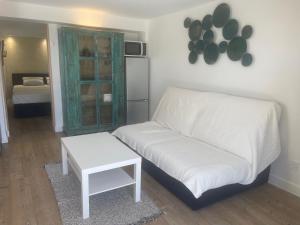 a living room with a white couch and a table at Bali 83 in Bandol