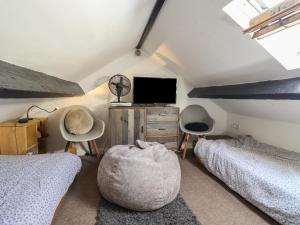 um quarto no sótão com 2 camas e uma televisão em 3 Barlwyd Terrace em Blaenau-Ffestiniog