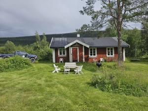 a red house with a picnic table in front of it at Villa Fregn in Ljørdalen