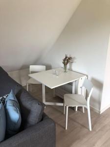 a living room with a white table and chairs at Bjælkehuset in Løkken