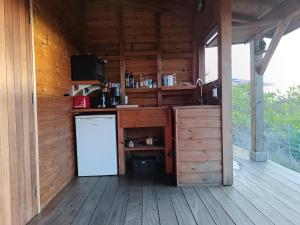 a kitchen in a wooden cabin with a refrigerator at TI KAZ ANOLI Cottage en bois avec vue sur la baie in Terre-de-Bas
