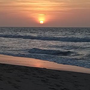 a sunset on the beach with the ocean at Hotel Juanmar in Juan de Acosta