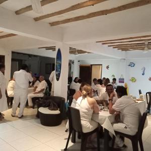 a group of people sitting at tables in a restaurant at Hotel Juanmar in Juan de Acosta