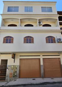 une maison avec deux portes de garage devant elle dans l'établissement CAXU HOSTEL, à Cachoeiro de Itapemirim